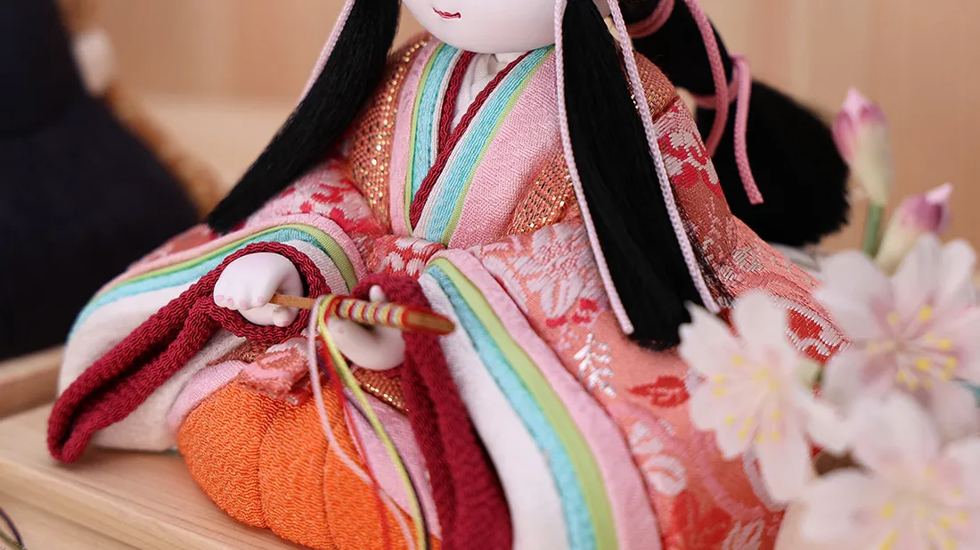 古典的な重ねの色合いを取り入れた女雛の衣装