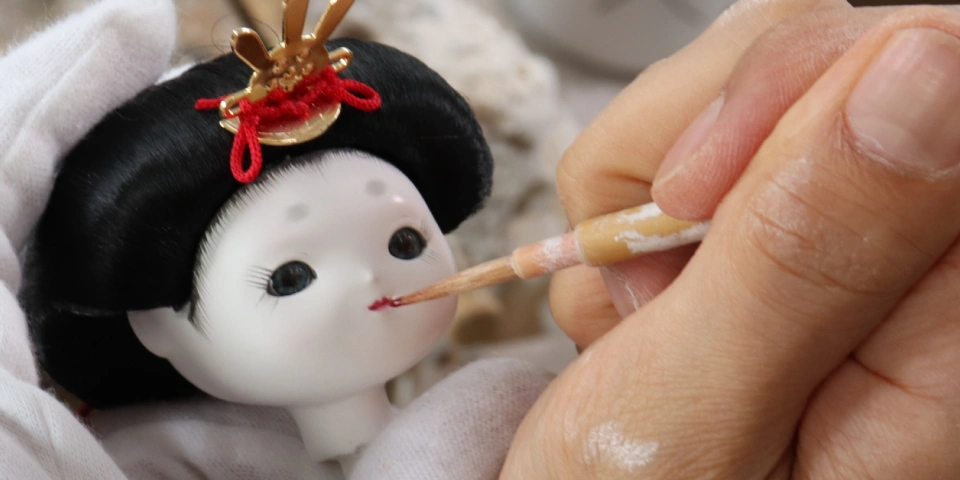 ひな人形の顔に彩色する職人の手元